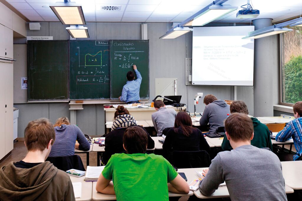 classroom with students, teacher and projection system